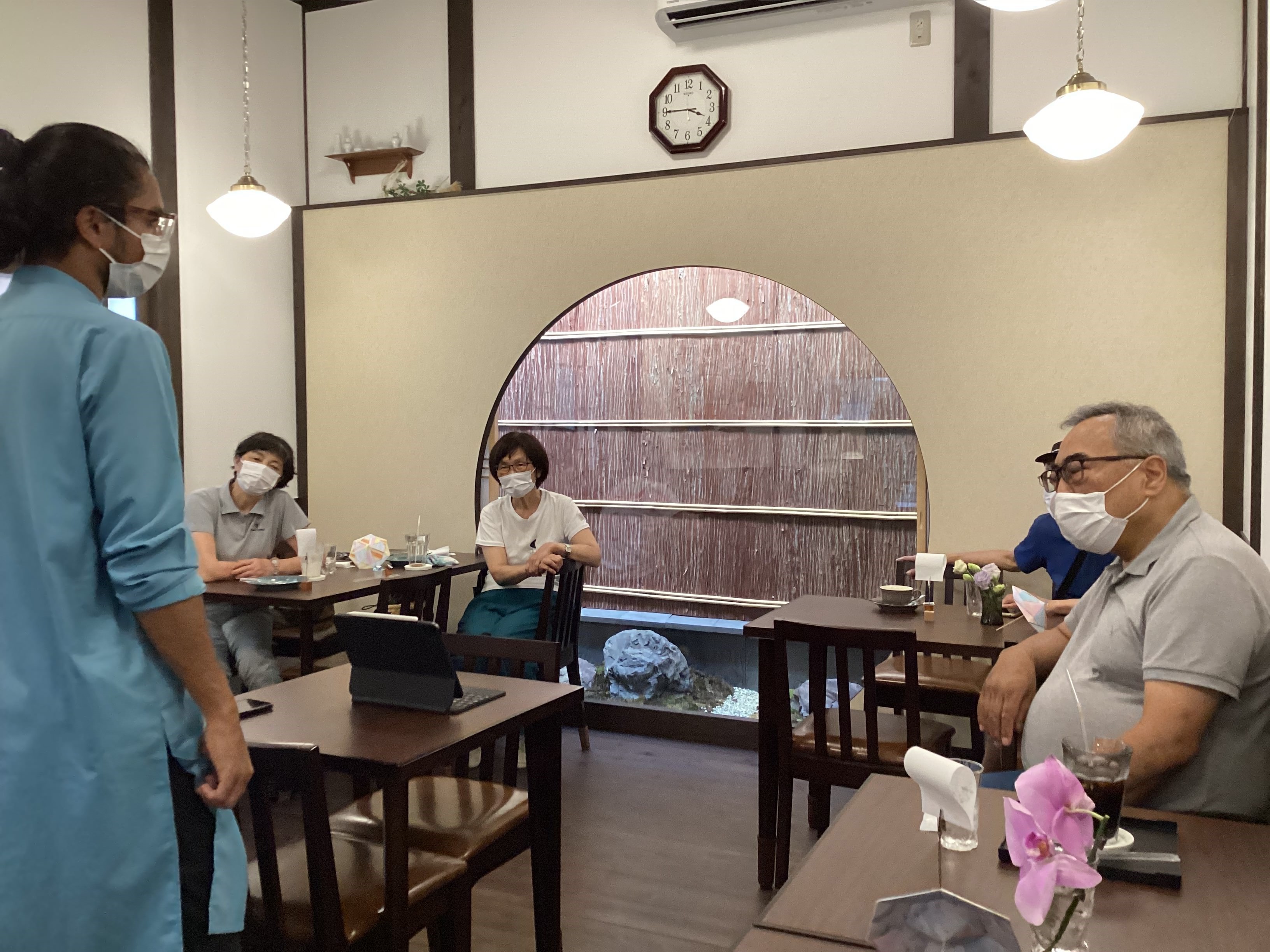 Inside the cafe, speaking to patrons and answering their questions.